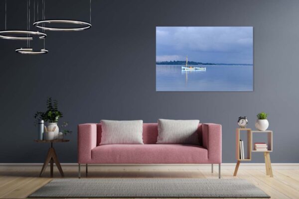 Moderne woonkamer met roze bank en kunst aan muur.