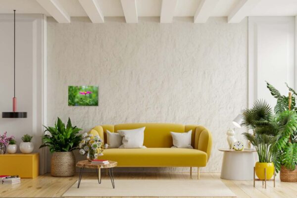 Moderne woonkamer met gele bank en groene planten.
