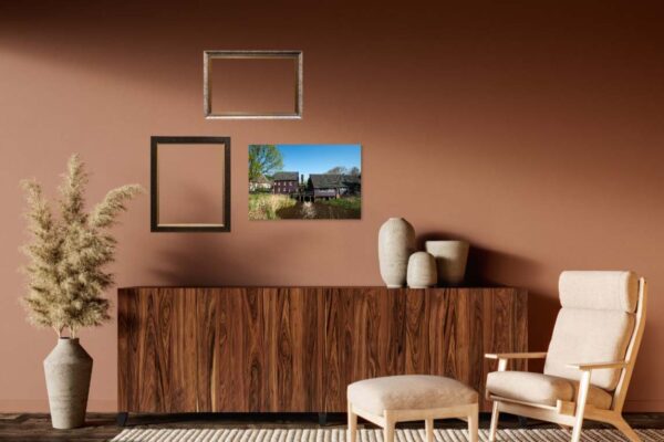 Moderne woonkamer met stoel, kast, en ingelijste foto's.