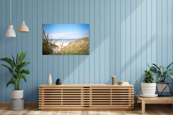 Modern interieur met strandfoto en kamerplanten.