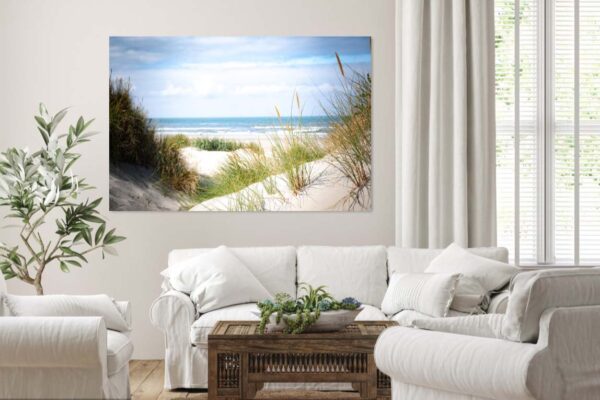 Woonkamer met witte banken en strandlandschap aan de muur.