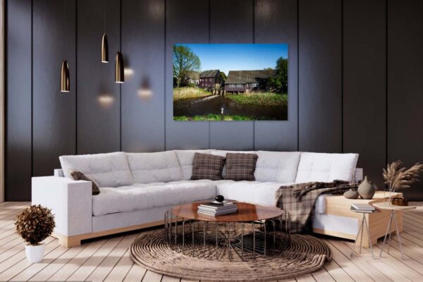 Moderne woonkamer met grijze hoekbank en landschapsschilderij.