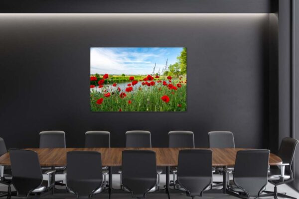 Vergaderzaal met landschapsschilderij en rode klaprozen.
