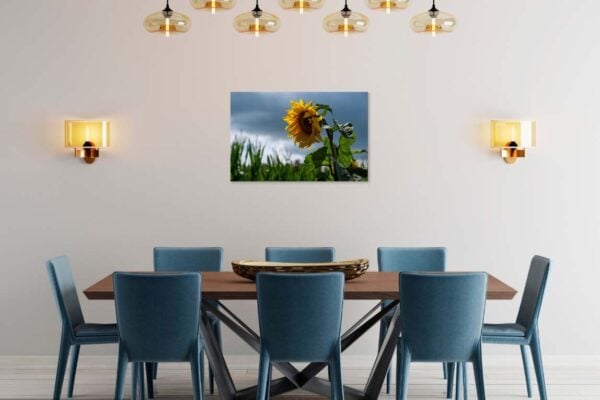 Moderne eetkamer met zonnebloemschilderij en blauwe stoelen.