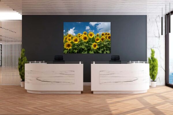 Moderne receptie met zonnebloemschilderij en houten vloer.